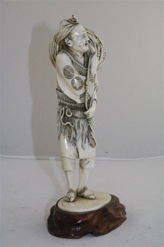 A large Japanese ivory figure of a fisherman, Meiji period, 25.5cm, wood stand